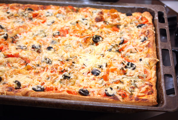 Печется пицца в разогретой до 190 градусов духовке минут 30. За это время тонкое тесто успевает приготовиться, сыр хорошо расплавиться, а начинка прогреться.  Конечно, вкуснее всего эта пицца в горячем виде.