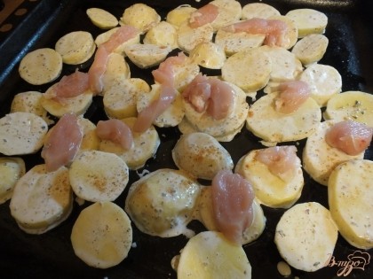 На противень раскладываем картошку в один слой, сверху равномерно курицу.