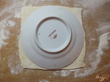 Тесто раскатываем в квадрат нужного размера. Берем блюдце на  5-7 см больше в диаметре чем горлышко горшочка. Тесто должно быть таким, чтобы блюдцу на нем поместилось. Вырезаем круг из теста по контуру блюдечка.