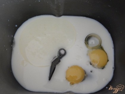 Наливаем тёплое молоко в ведёрко хлебопечки и оставляем в тёплом месте, минут на 15-20, чтобы разбудить дрожжи. Затем добавляем яйца и растительное масло..
