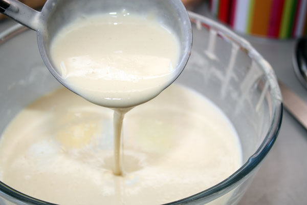После этого влить оставшееся молоко, добавить растительное масло и хорошо перемешать. Тесто должно быть достаточно жидким и текучим, чтобы блинчики получились тонкими.