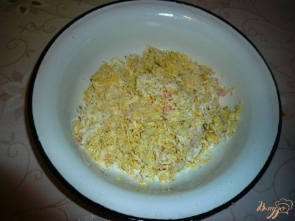 Затем на терке натираю куриные яйца. Соединяю крабовое мясо и яйца, добавляю майонез, перемешиваю.