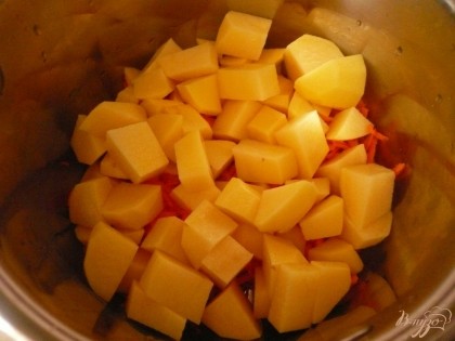 Картофель нарезаем крупными кусочками,толщиной полтора-два сантиметра,  выкладываем в кастрюлю с морковью.