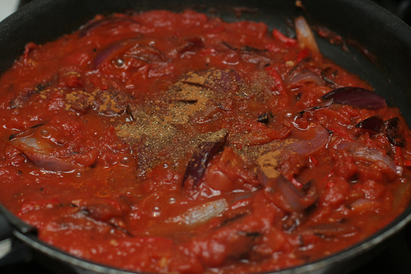 Влить томаты вместе с соком, перемешивая довести до кипения. Растолочь в ступке кориандр, зиру, корицу, соль и добавить в овощи.