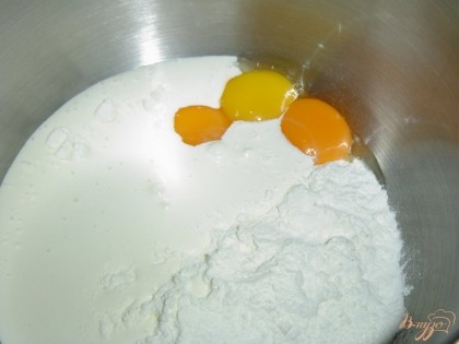 Черничную массу протираем через сито. Яйца разделяем на желтки и белки, нам потребуются только желтки. Желтки смешиваем с мукой и 100 мл сливок, взбиваем миксером.