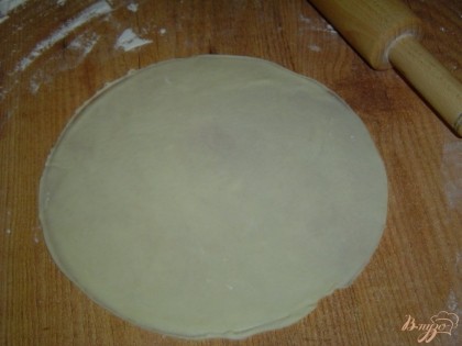 После того, как тесто подойдет, делим его на несколько равных частей, каждую из которых раскатываем в круглую лепешку, а чтобы все лепешки были более менее одного размера, можно сверху на лепешку положить тарелочку и по ней обрезать лишнее тесто.