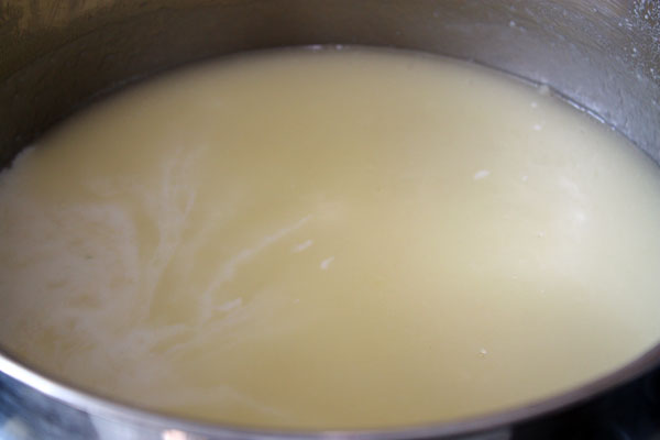 В муку нужно постепенно добавить молоко и капустный отвар, постоянно помешивая, чтобы не было комочков. Довести до кипения.