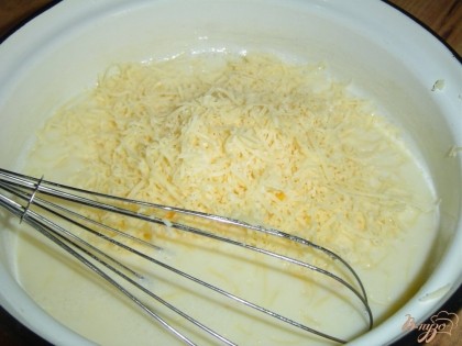 Овощи уложили на тесто и теперь осталось приготовить заливку. Слегка взбиваем яйца венчиком, добавляем молоко и еще раз взбиваем, затем кладем измельченный чеснок, натертый на мелкой терке сыр, солим по вкусу, и все тщательно перемешиваем.