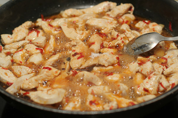 Положить в сковороду кусочки курицы и жарить, помешивая, пока они не побелеют. После чего, добавить рыбный соус (нам пла), соевый соус и сахар. Продолжать обжаривать еще 3−4 минуты, пока мясо не будет полностью готово.