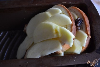 Форму смазать растопленным сливочным маслом. Уложить,  чередуя под небольшим наклоном  бриошь и яблоко с изюмом.