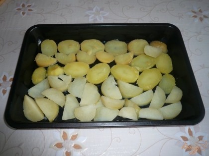 Противень для духовки смазываем растительным или сливочным маслом. Картофель нарезаем тонкими ломтиками и примерно половину (или чуть больше половины) всего картофеля выкладываем в один слой на дно формы.