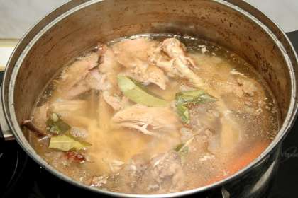 Положить куру в кастрюлю и залить ее холодной водой, чтобы она на 5 см покрыла курицу (примерно 4 литра). Поставить кастрюлю на сильный огонь.