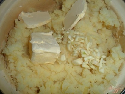 Когда картофель свариться, воду слить, размять картофель в пюре, добавить масло или маргарин и измельченный чеснок. Еще раз размять в пюре.