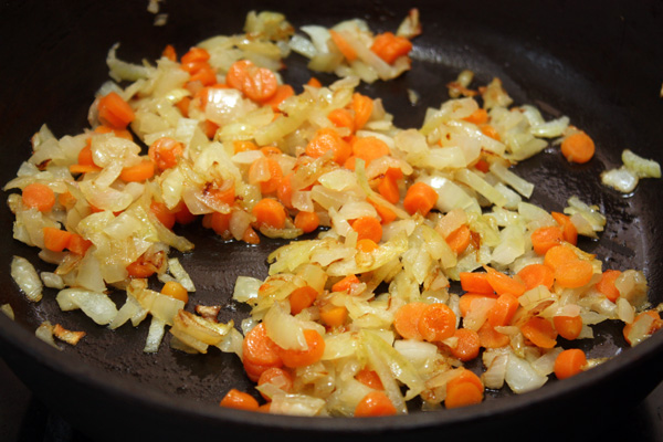 Добавляем морковь к луку и обжариваем все вместе, помешивая, около 5 минут.