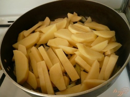 Пока готовится лук, нарезаем картофель крупными брусочками. Добавляем нарезанный картофель в сковороду к луку. На среднем огне, периодически помешивая, тушим картофель до готовности. Сковороду надо прикрыть крышкой.