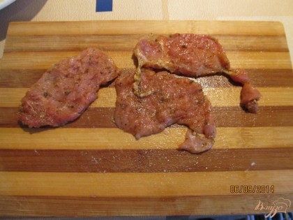 Для начала необходимо замариновать мясо. Для этого нарезаем его плоскими кусочками, отбиваем, посыпаем солью и специями.