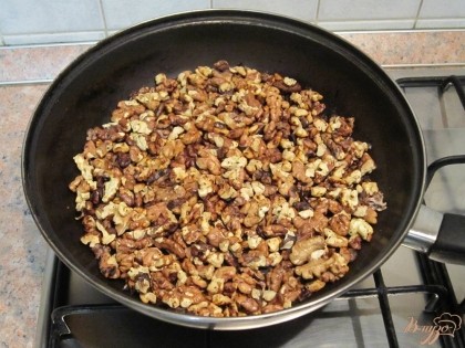 Обжарить грецкие орехи на сухой сковороде.