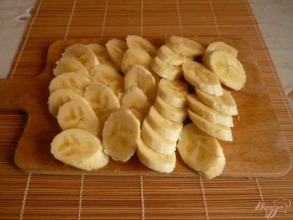 Нарезаю кружочками бананы.
