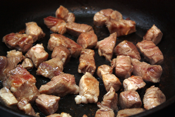В небольшом количестве масла обжарить кусочки мяса до золотистого цвета.