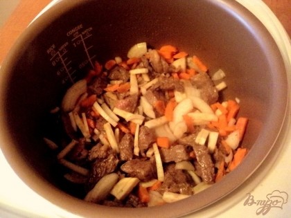 Говядину порезать кусочками размером 2.5х2.5см. В чаше мультиварки разогреть растительное масло. Положить нарезанную говядину по обжарить в режиме «Жарка» 5 минут. Добавить нашинкованные лук, морковь, корень сельдерея и готовить 10 минут.
