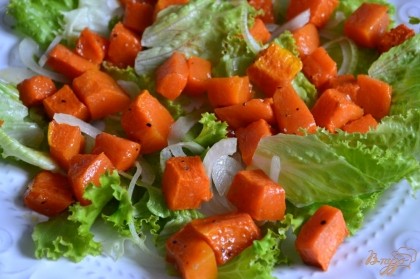 На большую тарелку выложить листья салата и полукольца лука (по вкусу)Затем добавить кусочки печеной тыквы.