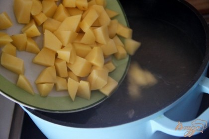Вскипятить бульон, добавить размятую морков и картофель, нарезанный небольшим кубиком, варить 15 мин.