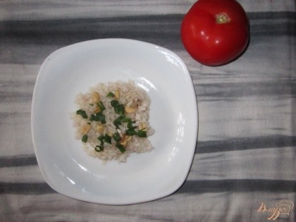 Рис выкладываем на тарелку, перчим. Добавляем нарезанный зеленый лук и арахис.