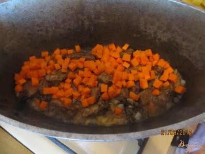 Далее в казан добавляем морковь и также все вместе обжариваем.