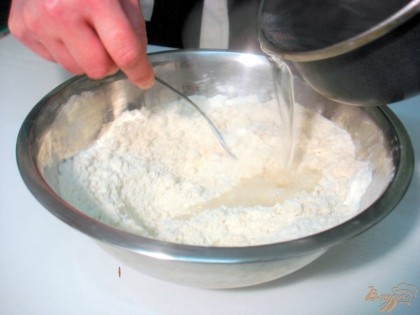 Воду доводим до закипания и вливаем кипяток в муку быстро перемешивая вилкой тесто.