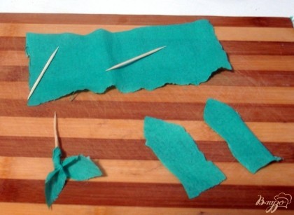 Из зелёной гофрированной бумаги вырезаем листочки и накручиваем на зубочистку.