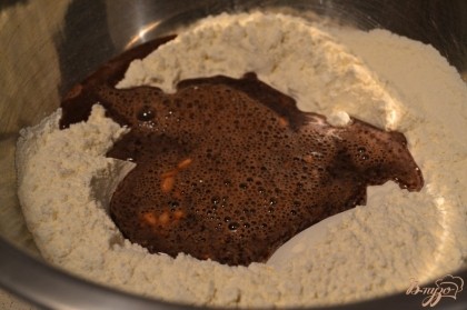 В большую миску просеять  муку, сделать углубление в которое вылить яично-шоколадную смесь. Замесить мягкое тесто.