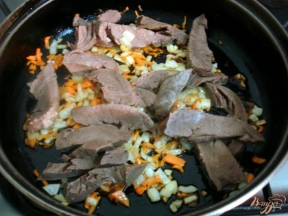 Когда лук и морковь станут мягкими добавим к ним нарезанное брусочками мясо. Обжариваем вместе 2 минуты