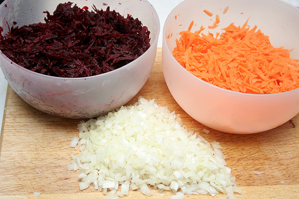 Свеклу и морковь очистить, вымыть и натереть на крупной терке. Лук очистить и мелко нарезать.