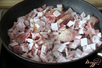 Мелко нарезать копчености и колбасные изделия. Обжарить на сковороде до румяности: бекон, копченую грудинку, вареную шинку.