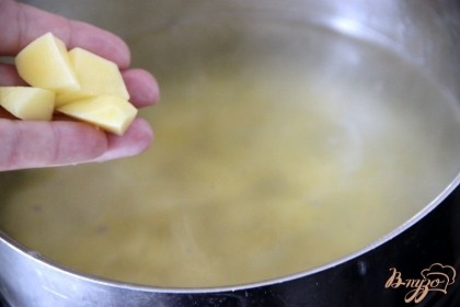 Пока жарятся колбасные изделия, разогреть  бульон с водой, добавить картофель, нарезанный небольшими кубиками. Варить 10 мин.