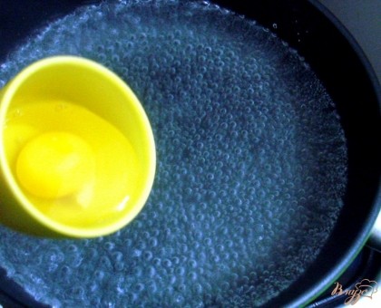 Выливаем яйцо на кипяток, огонь убавляем до минимума. Следим за яйцом, чтобы определить степень готовности. Мы любим когда желток жидкий, а белок свернулся. Время указать сложно. Всё зависит от того, какой газ под сковородой.