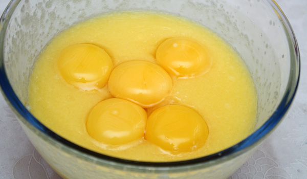 В растопленное сливочное масло добавляем сахар и яичные желтки. Смешиваем до однородности массы и взбиваем.