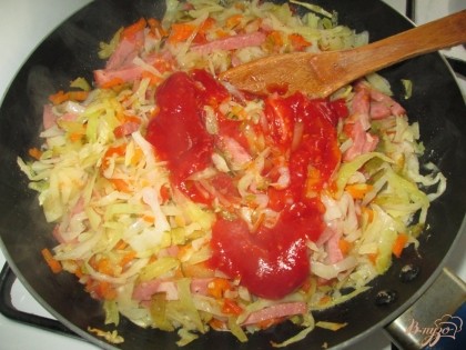Через 10 минут после начала жарки добавить томатную пасту и перемешать. Жарить до готовности капусты.