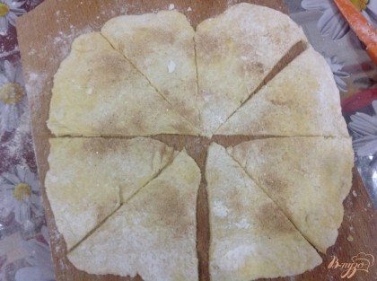 Посыпаем тесто сахаром с корицей, и разрезаем круг на 8 частей, на низ каждого треугольника выкладываем варенье, и сворачиваем в рогалик