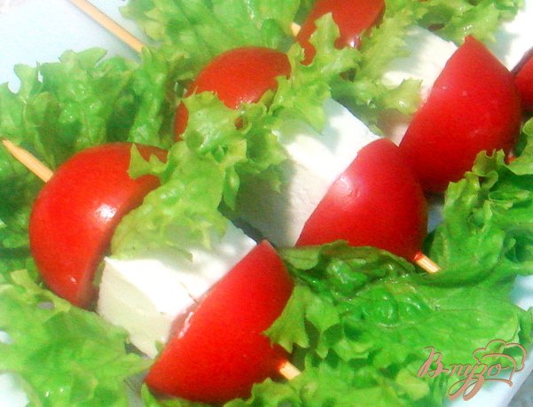 На палочку нанизываем половину помидоринки, листочек салата, сыр и вторую половинку помидора.