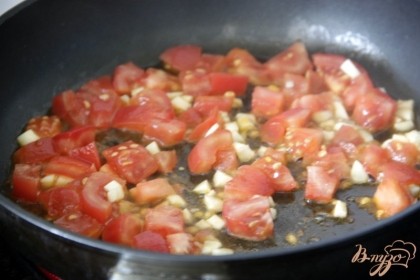 На разогретом масле подрарить вначале слегка чеснок, затем добавить помидоры, тушить, помешивая до готовности