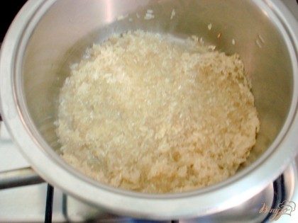 Промывать его не будем, а приготовим так, как делают греческие хазяюшки. В кастрюле разогреваем растительное масло, высыпаем в него рис, перемешаем. Прокаляем рис в течении двух, трёх минут, пока рис не станет прозрачным.