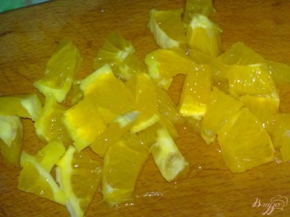 Апельсин помыть, очистить и нарезать кубиками.