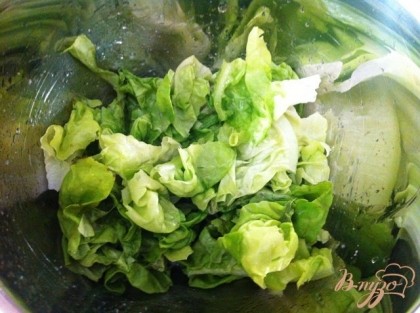 Рвём руками салатные листья, сбрызгиваем их лимонным соком и поливаем оливковым маслом
