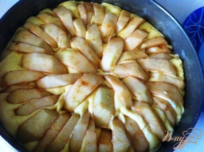 Полученную массу выложить в смазанную форму для выпечки. Воткнуть в тесто по кругу выпуклой стороной вверх, плотно друг к другу по всей поверхности пирога (чем больше яблок, тем пирог получится сочнее). Сверху посыпать коричневым сахаром.