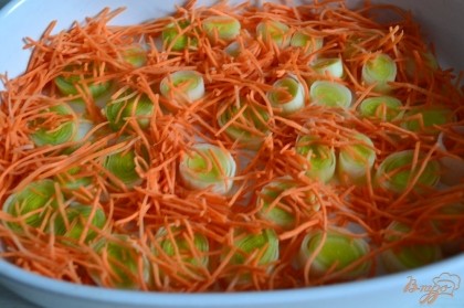 Керамическую форму для запекания смазать оливковым маслом. Разложить морковь и колечки порея.
