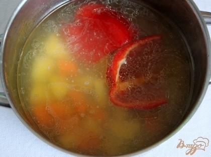 В образовавшийся бульон добавить картофель + морковь, нарезанные кубиками, колечками, перец - половинками, варить 15 мин.