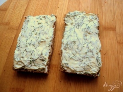 У ломтиков хлеба обрезать корки и намазать слоем сыра с укропом.