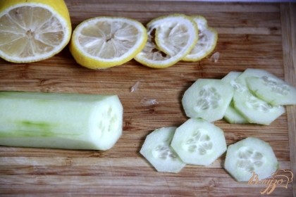 Очищеннй огурец и лимон нарезать тонкими кружочками