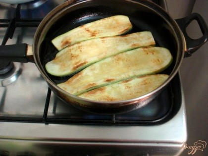 Разогреваем на сковороде растительное масло и обжариваем слегка кабачки с двух сторон.